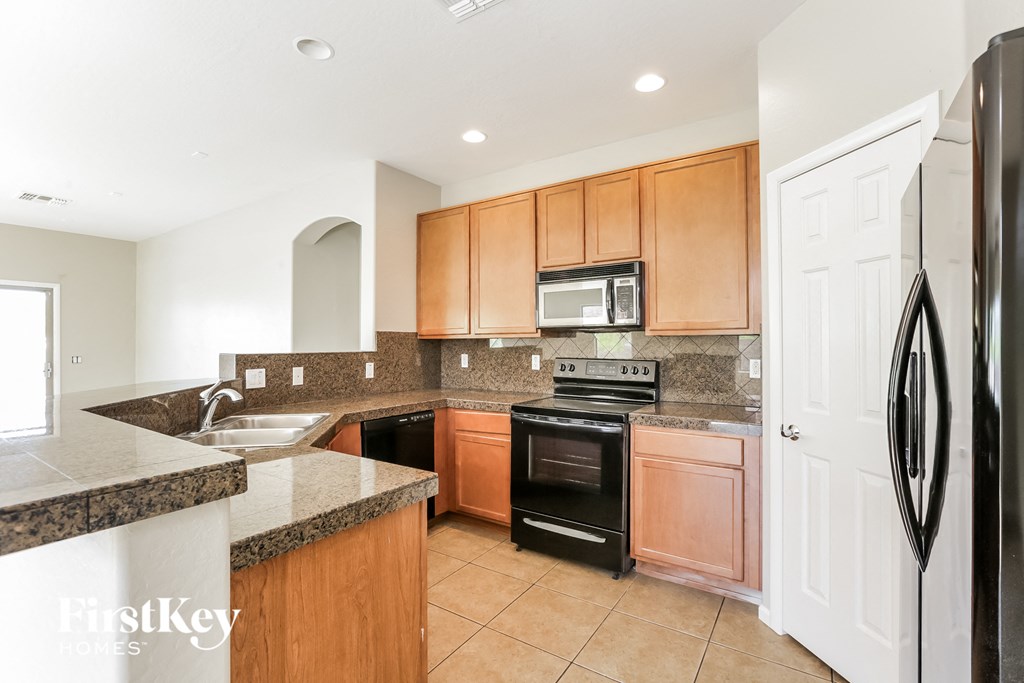 A kitchen with wooden cabinets and black appliances.