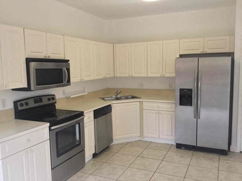 A kitchen with white cabinets and a black stove top oven.