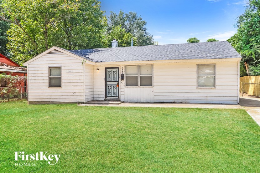 A small house with a black door and a grey roof.