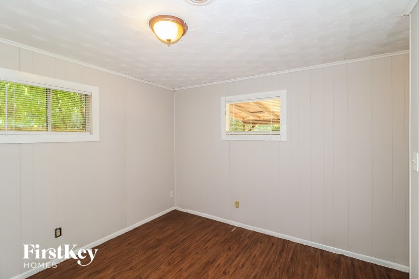 A room with a window and a picture on the wall.