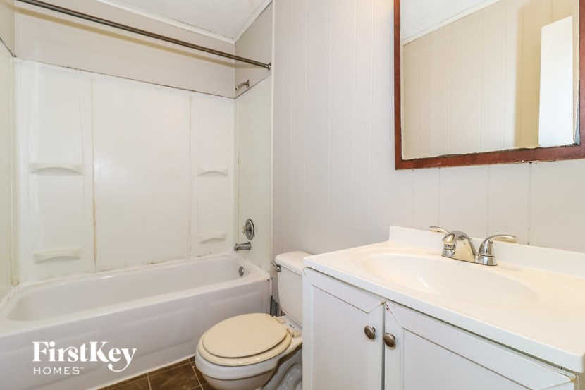 A white bathroom with a toilet, sink, and bathtub.
