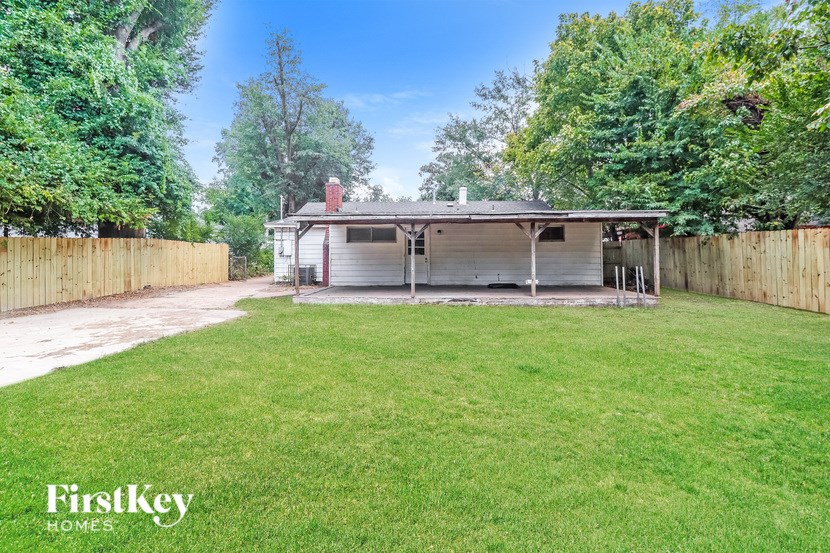 A backyard with a fence and a house.
