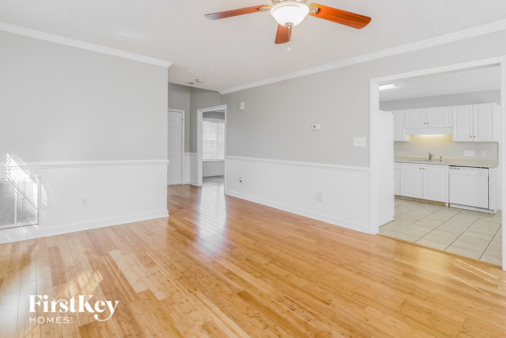 A room with wooden floors and a ceiling fan.