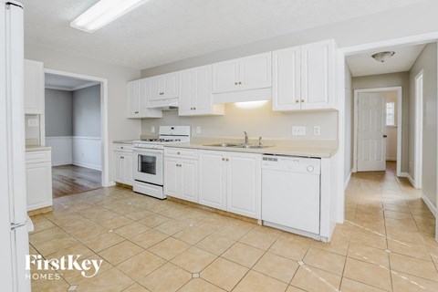 A kitchen with white cabinets and appliances in a house.