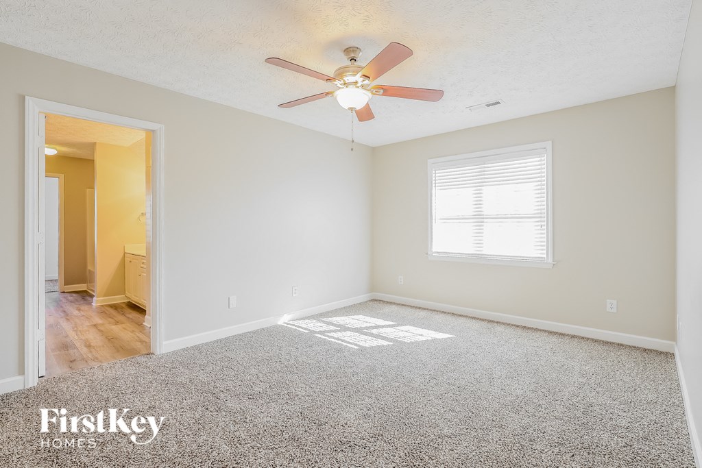 A spacious room with a ceiling fan and a window.