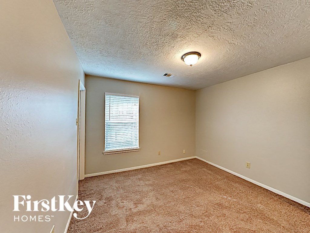 an empty room with carpet and a window