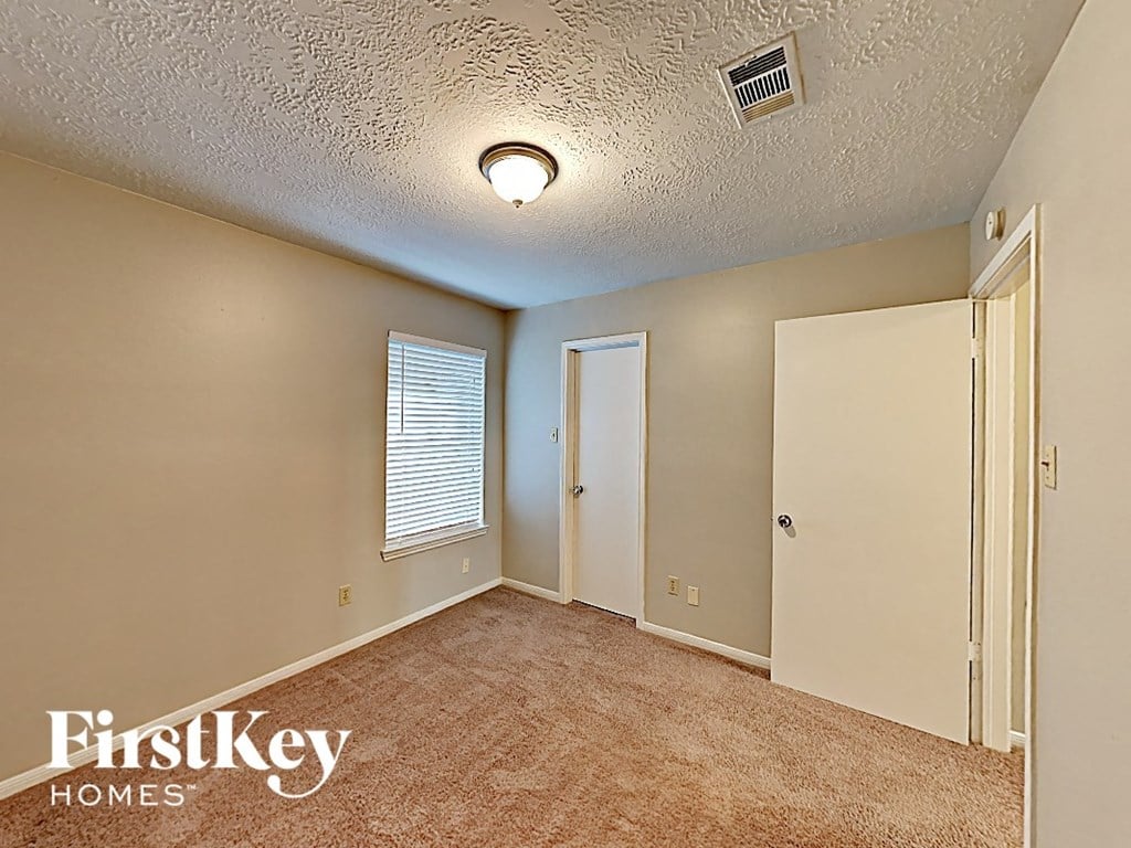 an empty room with a door and a window and a ceiling fan