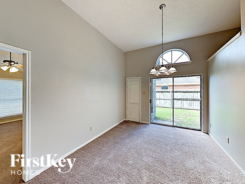 an empty living room with a sliding glass door to the patio