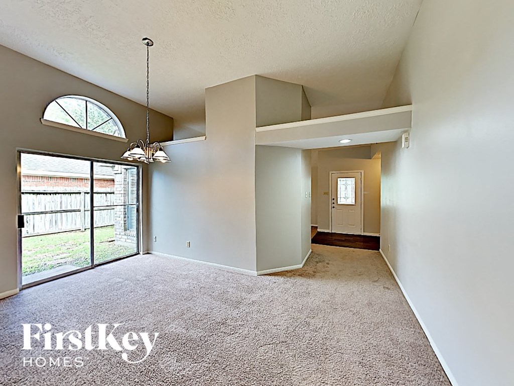 an empty living room with a sliding glass door to a patio