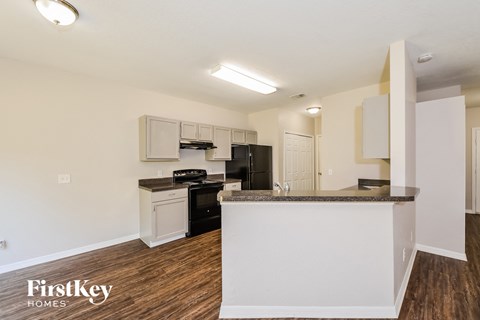 A kitchen with a white counter and black appliances.