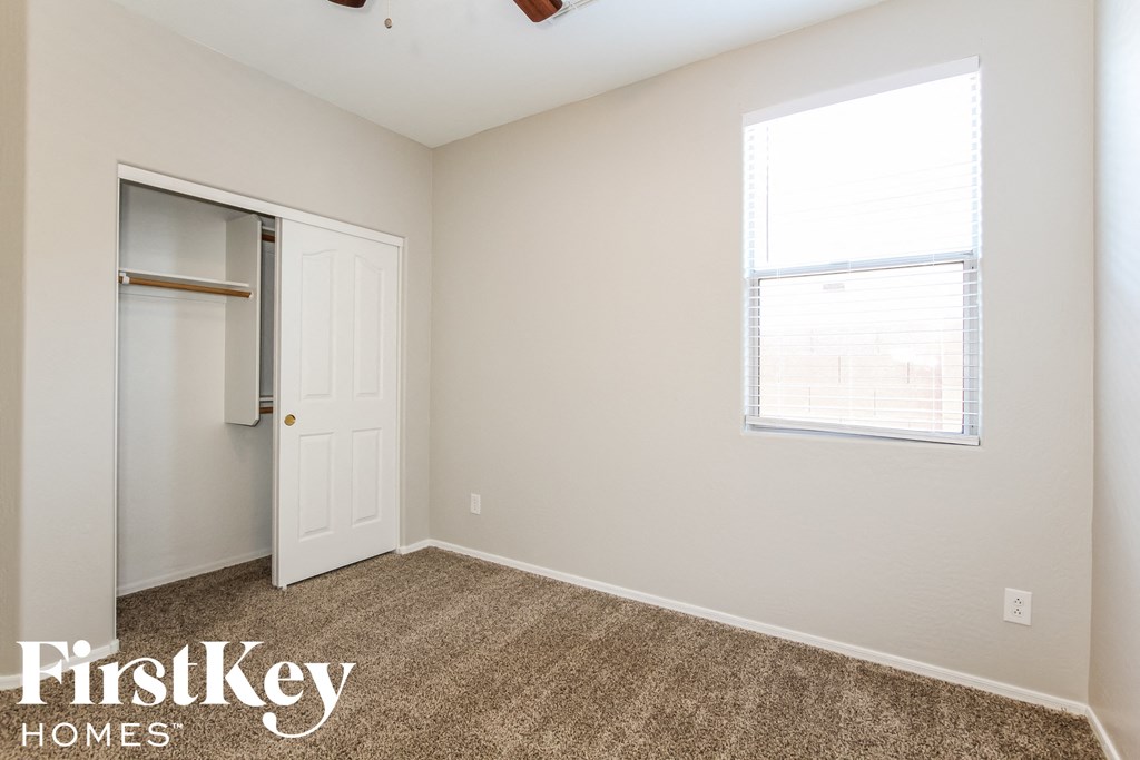 a bedroom with carpet and a door to a closet