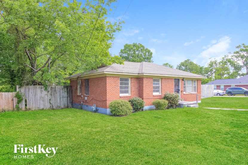 A brick house with a green lawn in front.
