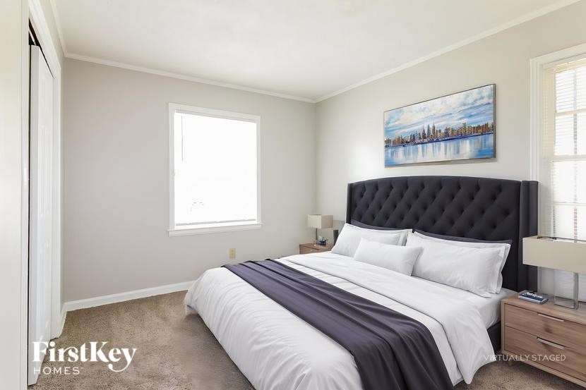 A bedroom with a large bed and a painting on the wall.