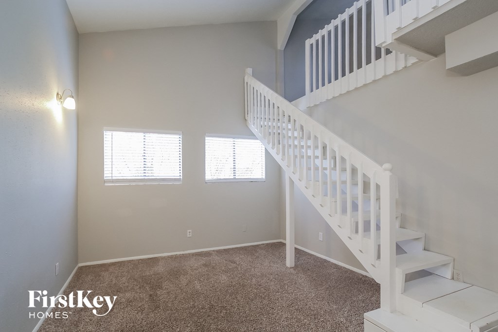 A white staircase in a room with a carpeted floor.