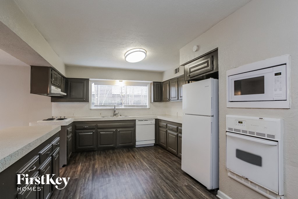 A kitchen with a white fridge and white oven.