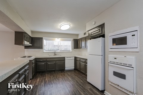 A kitchen with a white fridge and white oven.
