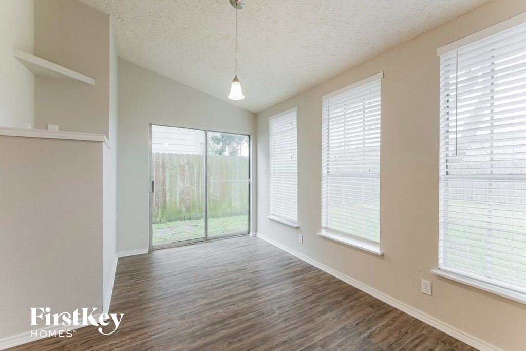 an empty living room with wood floors and a sliding glass door