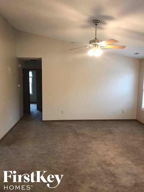 A room with a ceiling fan and a door.