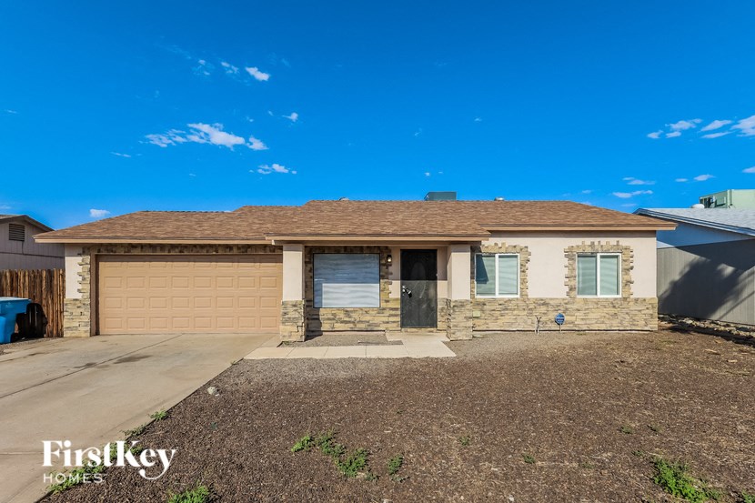 a small brick house with a garage and a driveway