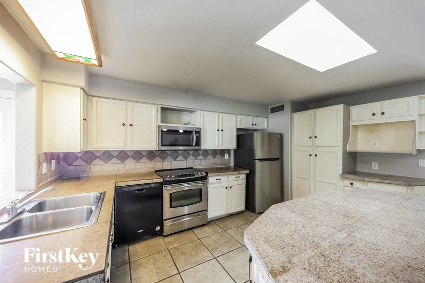 a large kitchen with granite counter tops and stainless steel appliances