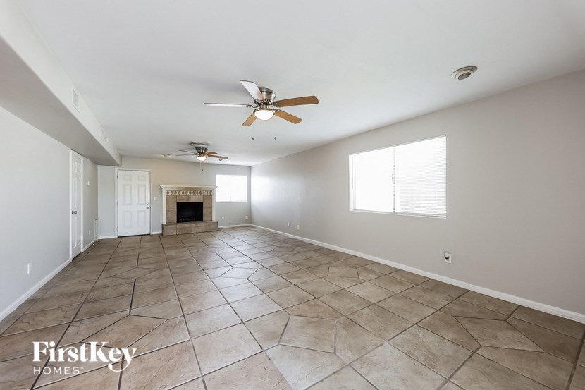 a large living room with tile flooring and a ceiling fan
