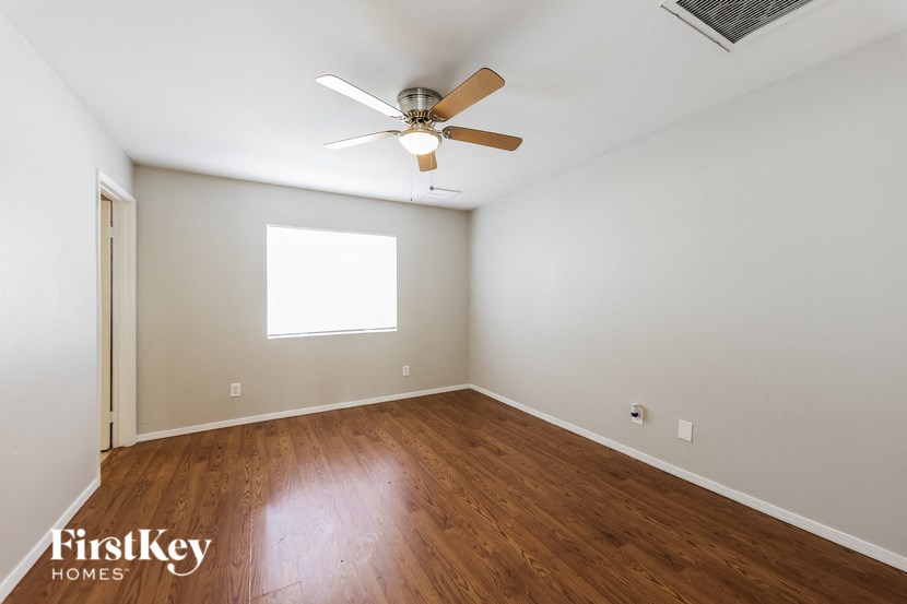 a living room with wood floors and a ceiling fan