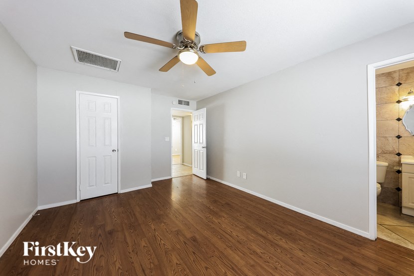a living room with wood floors and a ceiling fan