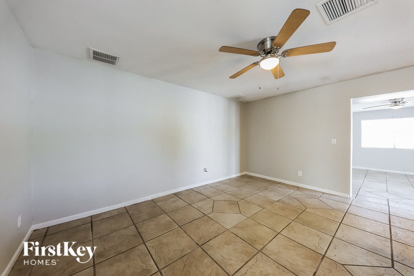 the living room has a ceiling fan and tile flooring
