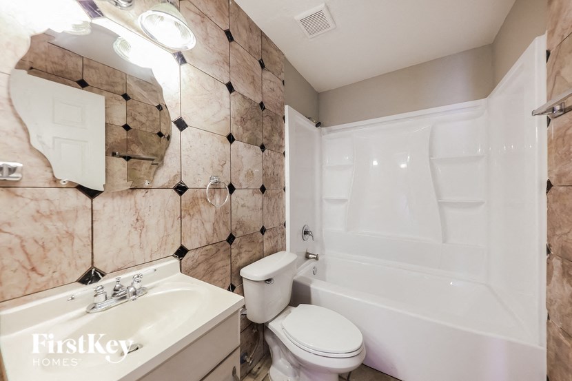 a bathroom with a toilet and a sink and a tub