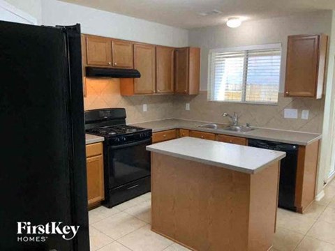 A kitchen with wooden cabinets and black appliances.