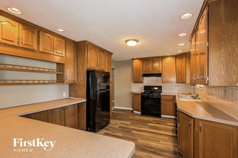 a kitchen with wooden cabinets and black appliances