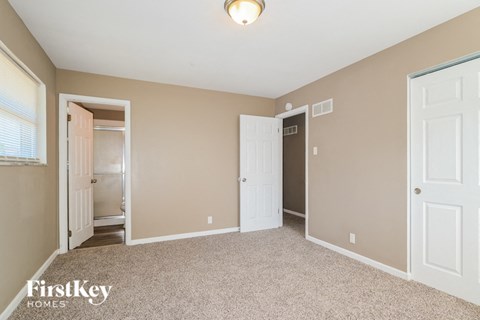 a bedroom with two closets and a door to a bathroom