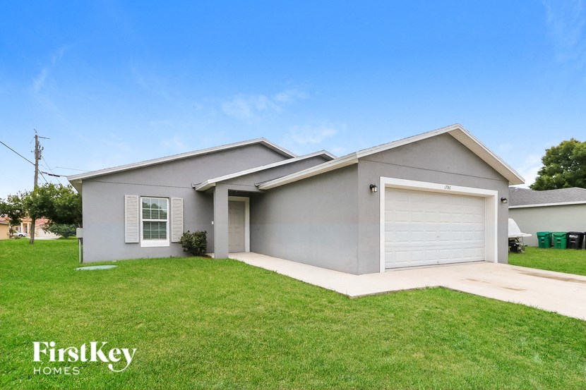 a gray house with a lawn and a garage door