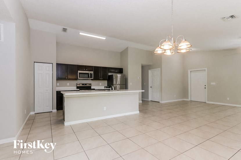 an open kitchen and living room with a large counter top