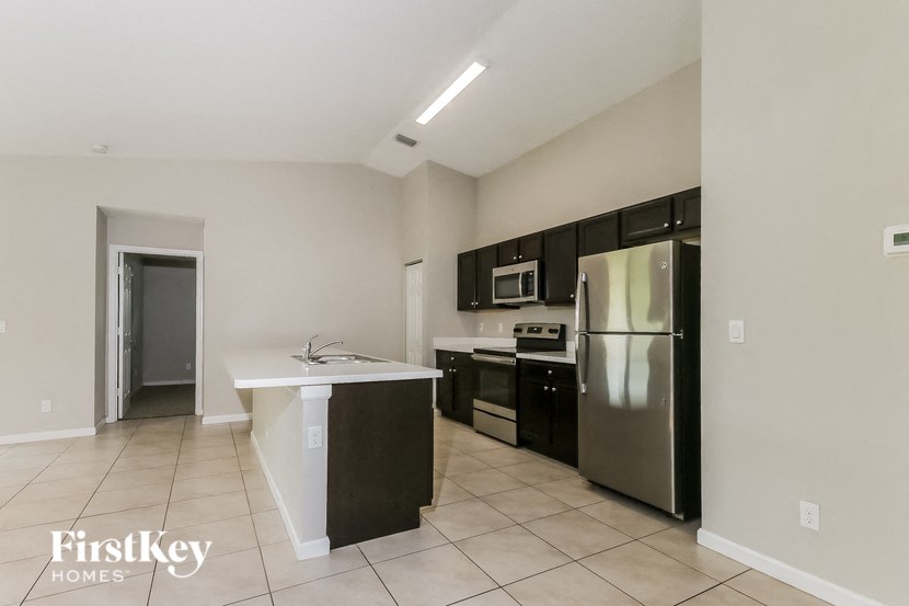 a kitchen with a stainless steel refrigerator and a sink
