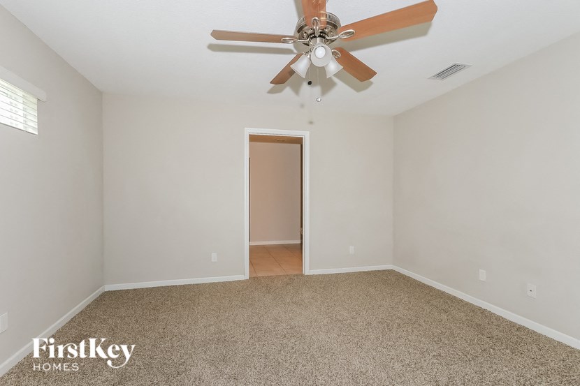 the living room of an empty house with a ceiling fan