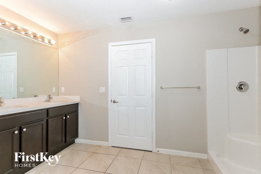 a bathroom with a shower and a sink and a mirror