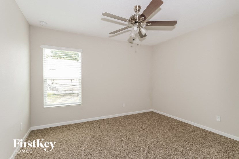 a bedroom with carpet and a ceiling fan
