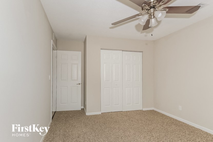 a bedroom with two closets and a ceiling fan