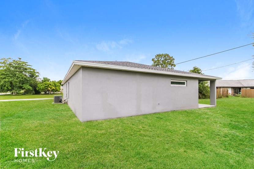 the view of the backyard of a small white house