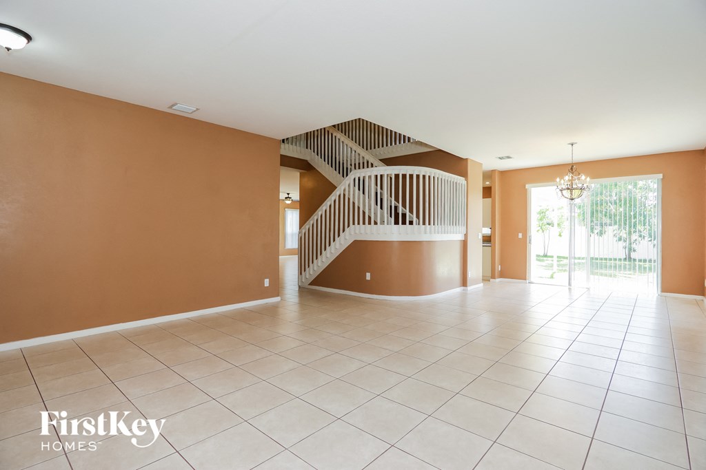 an empty living room with a staircase in the center of it
