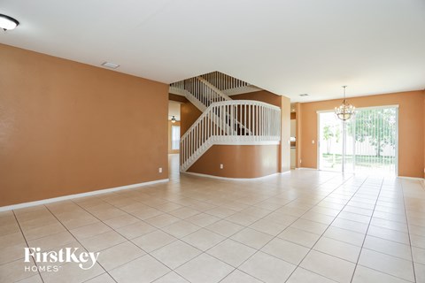an empty living room with a staircase in the center of it