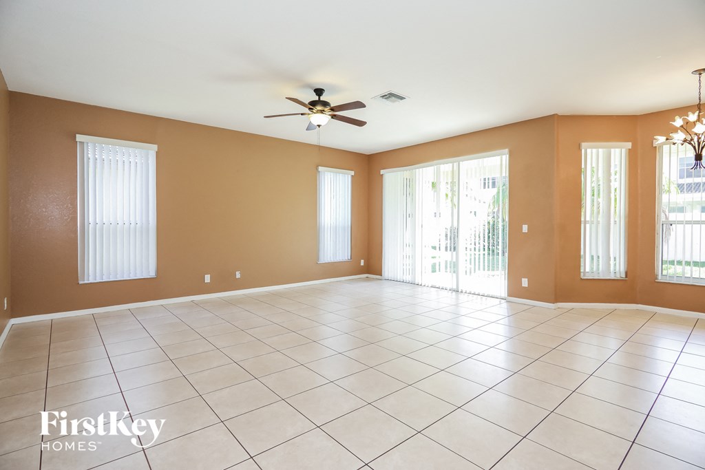 an empty living room with a ceiling fan