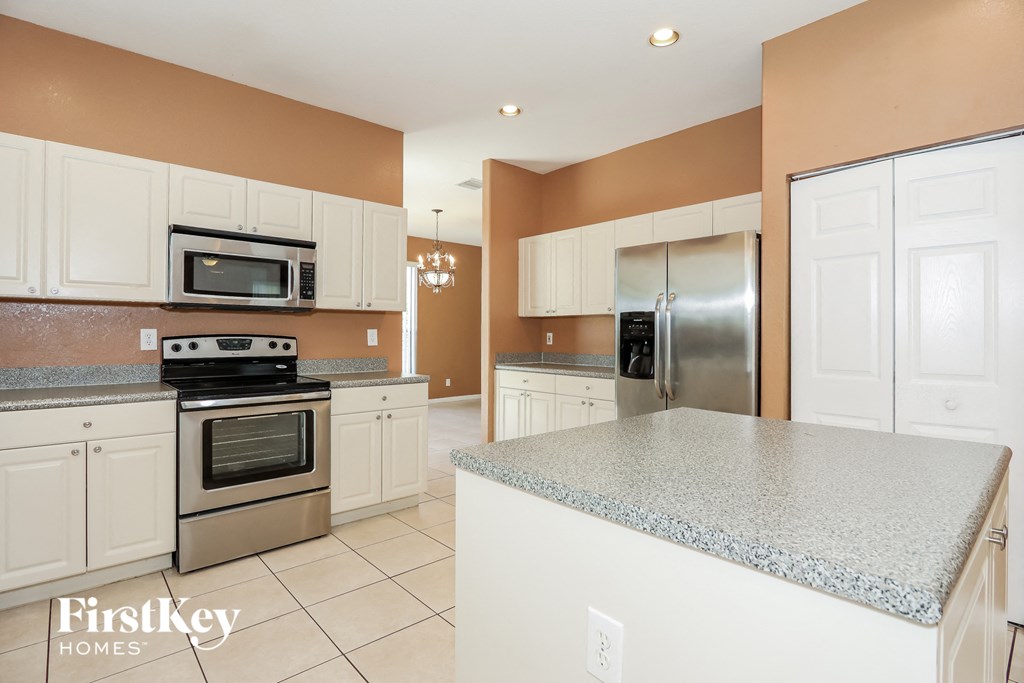 a kitchen with white cabinets and stainless steel appliances and granite counter tops