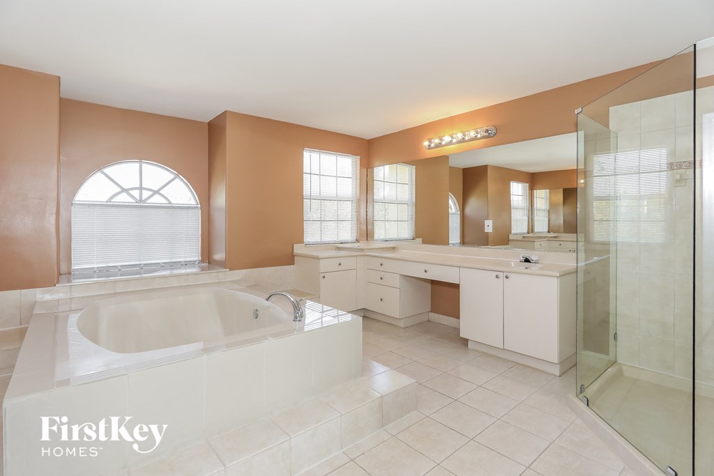 a large white bathroom with a large tub and a shower