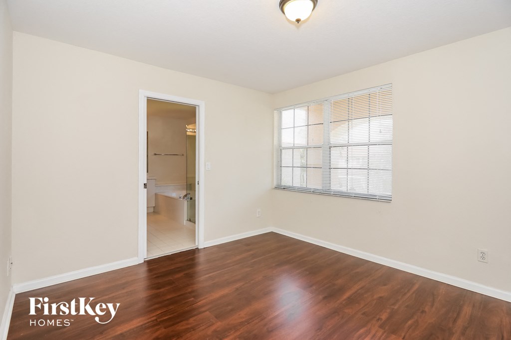 an empty living room with wood flooring and a large window