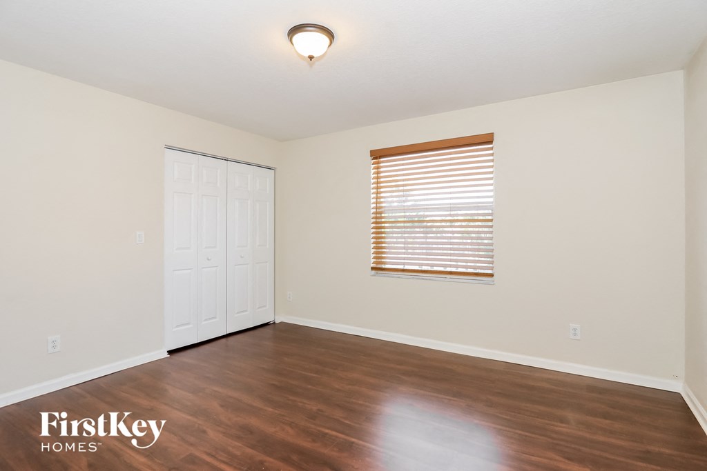 the living room of an empty house with wood floors and a window