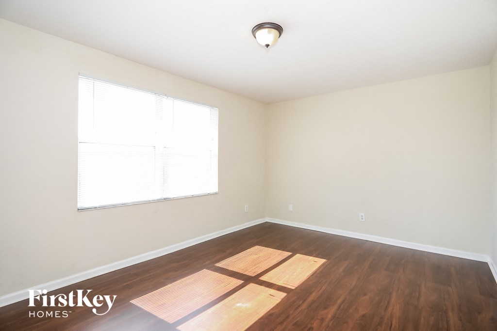 an empty room with wood floors and a window