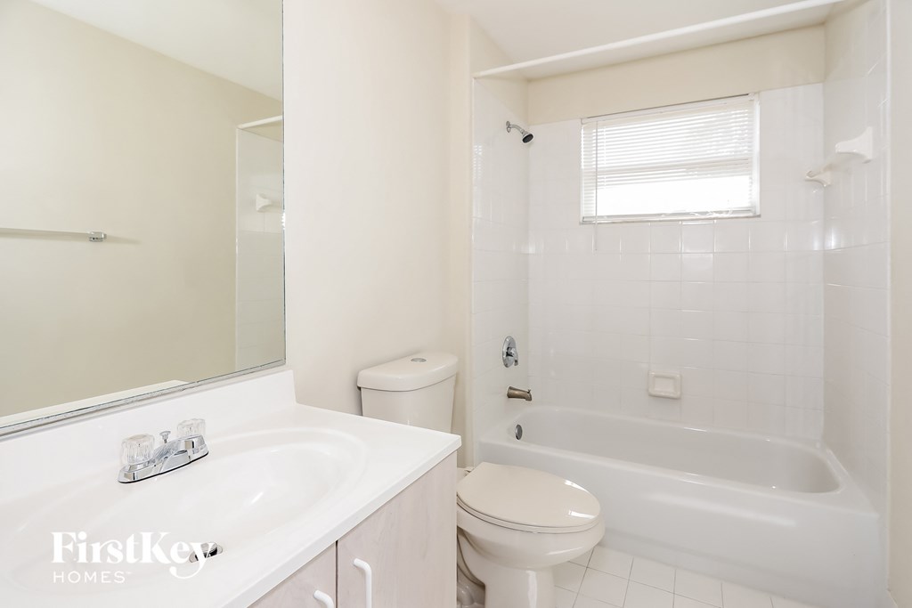 a bathroom with a toilet and a tub and a sink
