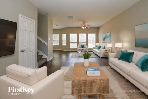 A well-lit living room with a white couch and a coffee table.